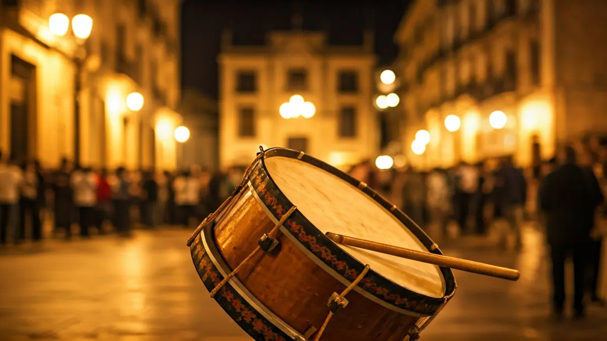 Imatge d'un tambor de les festes de Moros i Cristians, amb gent i edificis històrics al fons.