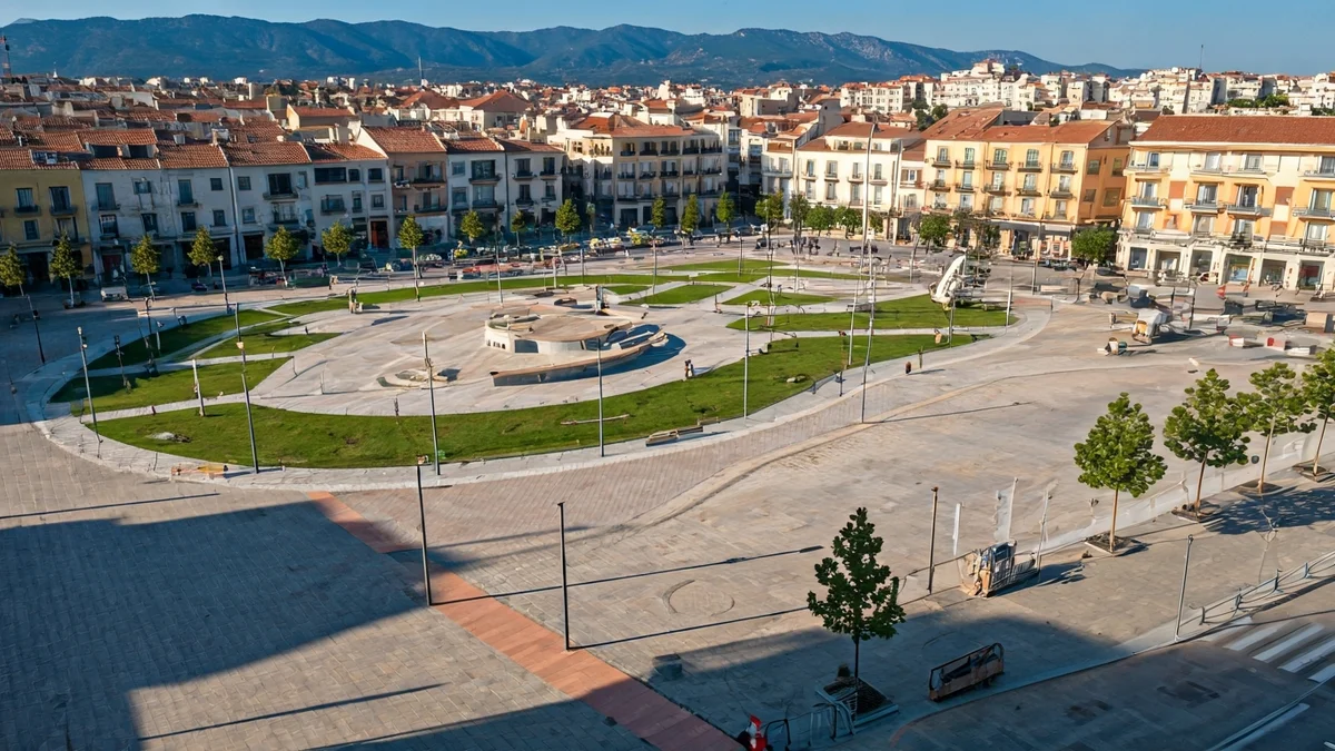 Aerial view of a square under renovation with permeable pavements and green areas.