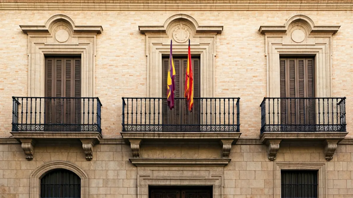 Facade of Benicàssim town hall with balcony and iron railings, illuminated by the afternoon sun.