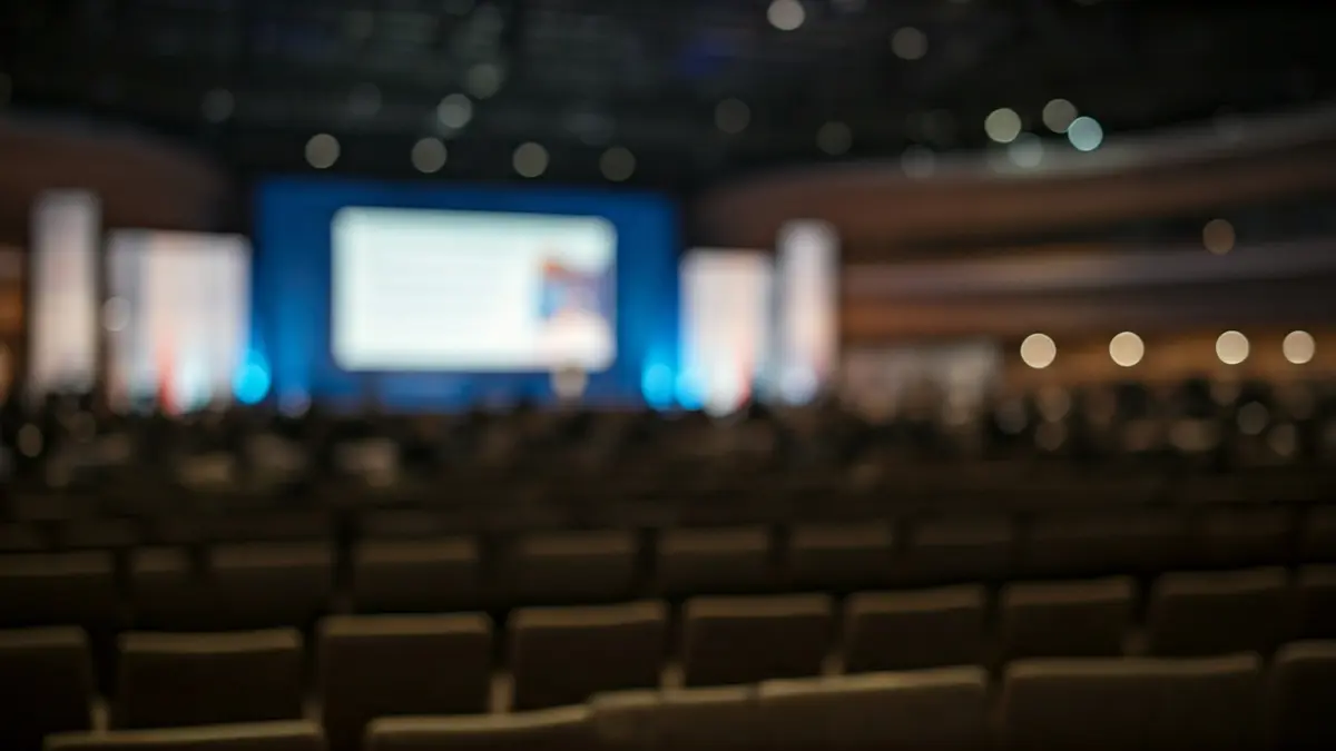Generic image of an international forum or summit, with an empty conference hall and a large screen.