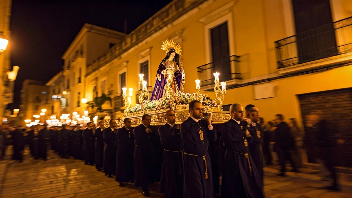 Imagen de una procesión religiosa nocturna con figuras borrosas y esculturas iluminadas.