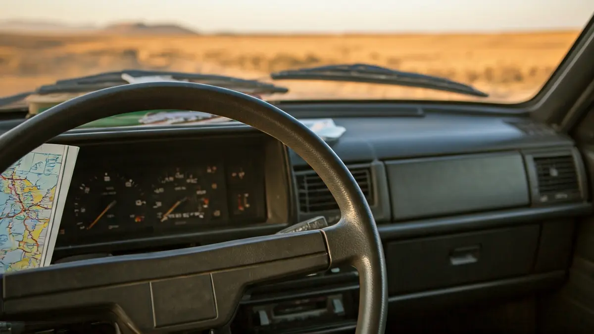 Imagen de un coche clásico con material escolar, simbolizando un viaje solidario por el desierto.