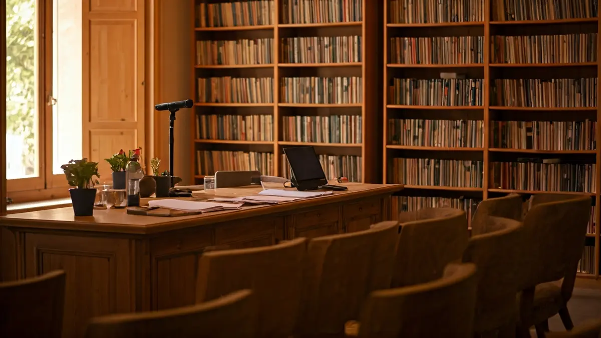 Imatge genèrica d'un interior de biblioteca amb prestatgeries de fusta i un faristol amb micròfon.