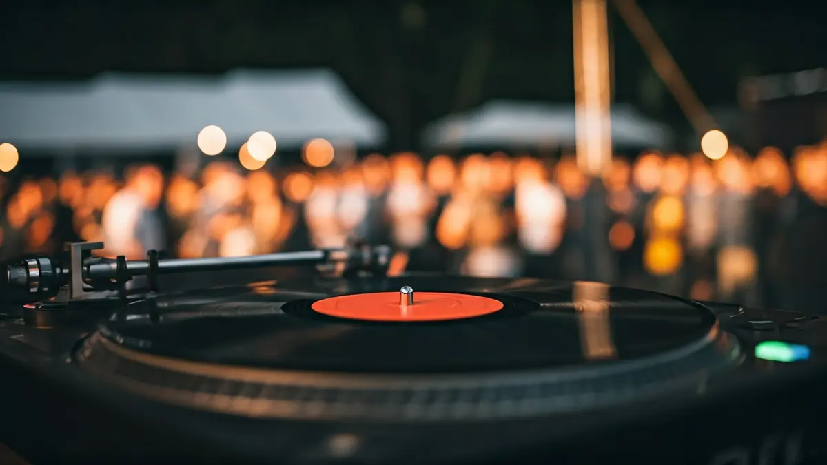Imagen genérica de un disco de vinilo girando en un tocadiscos, con luces de escenario borrosas al fondo.