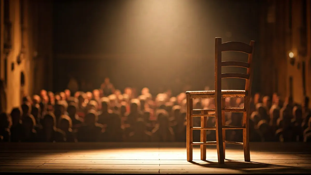 Imagen de un escenario de teatro con una silla de madera, evocando la austeridad de una compañía de teatro ambulante del Siglo de Oro.