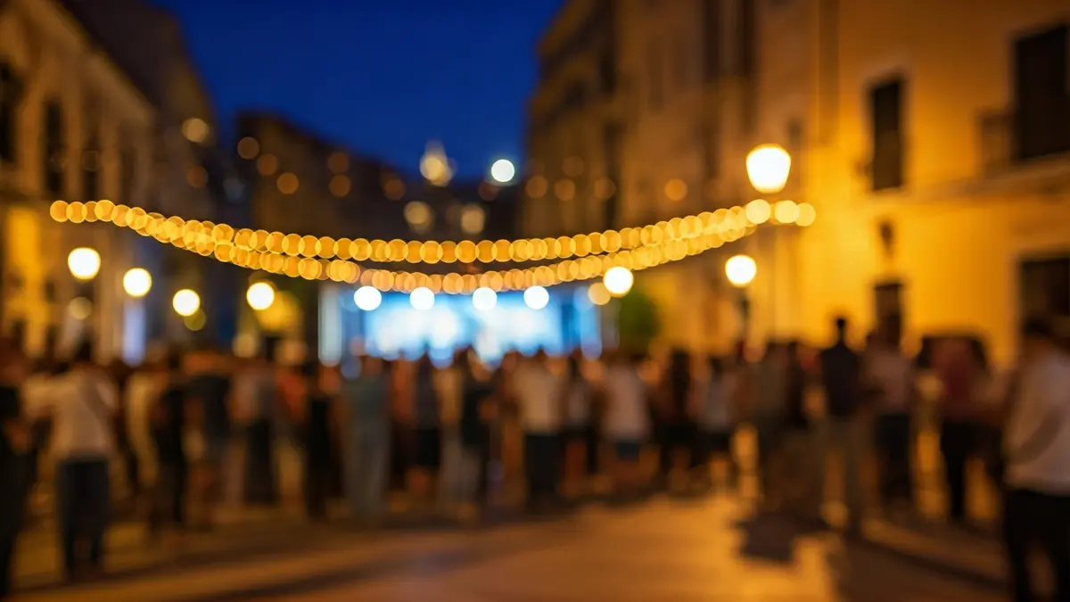 Imagen de un festival de música flamenca en una plaza mediterránea con gente y luces.
