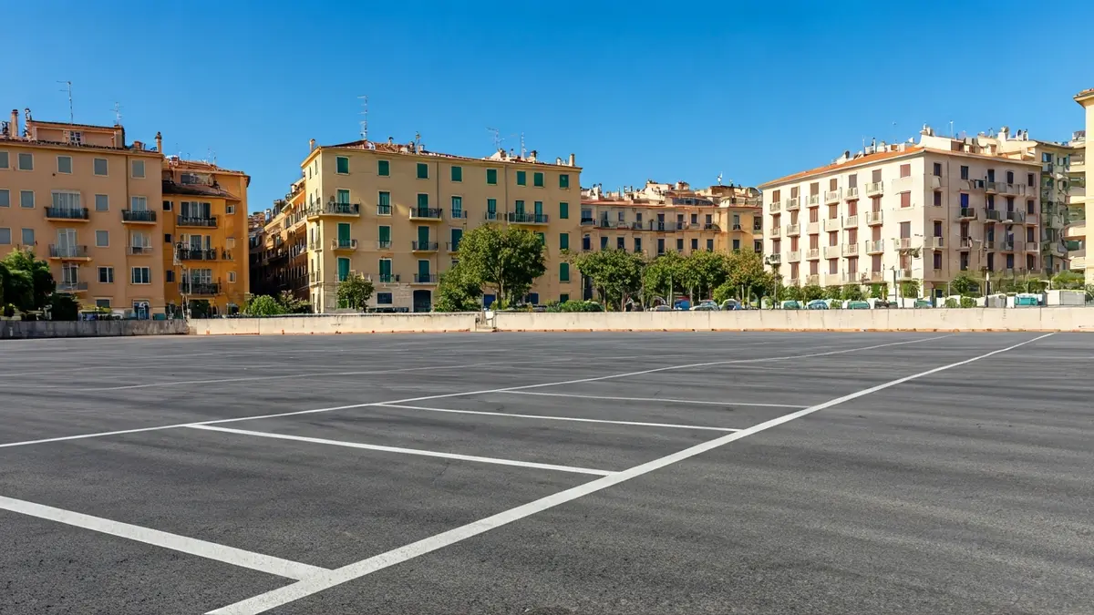 Imagen genérica de un aparcamiento vacío con edificios mediterráneos al fondo.