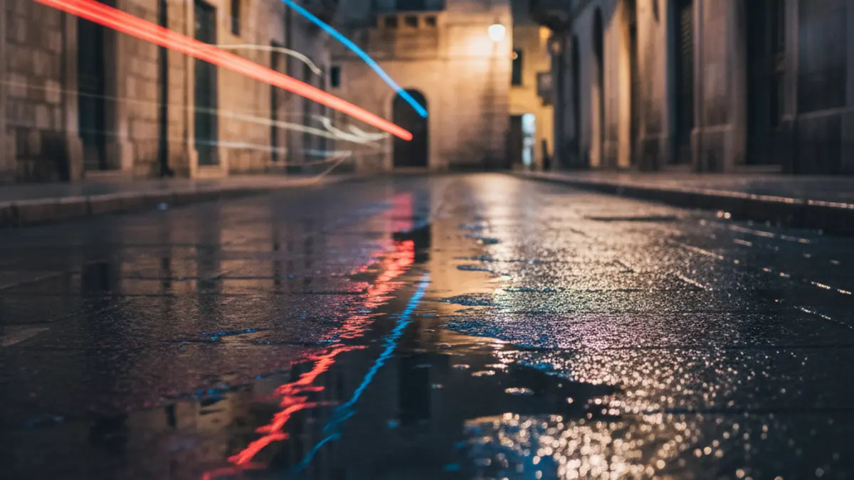 Generic image of emergency lights reflecting on wet asphalt at night, no vehicles visible, in a Mediterranean urban setting.