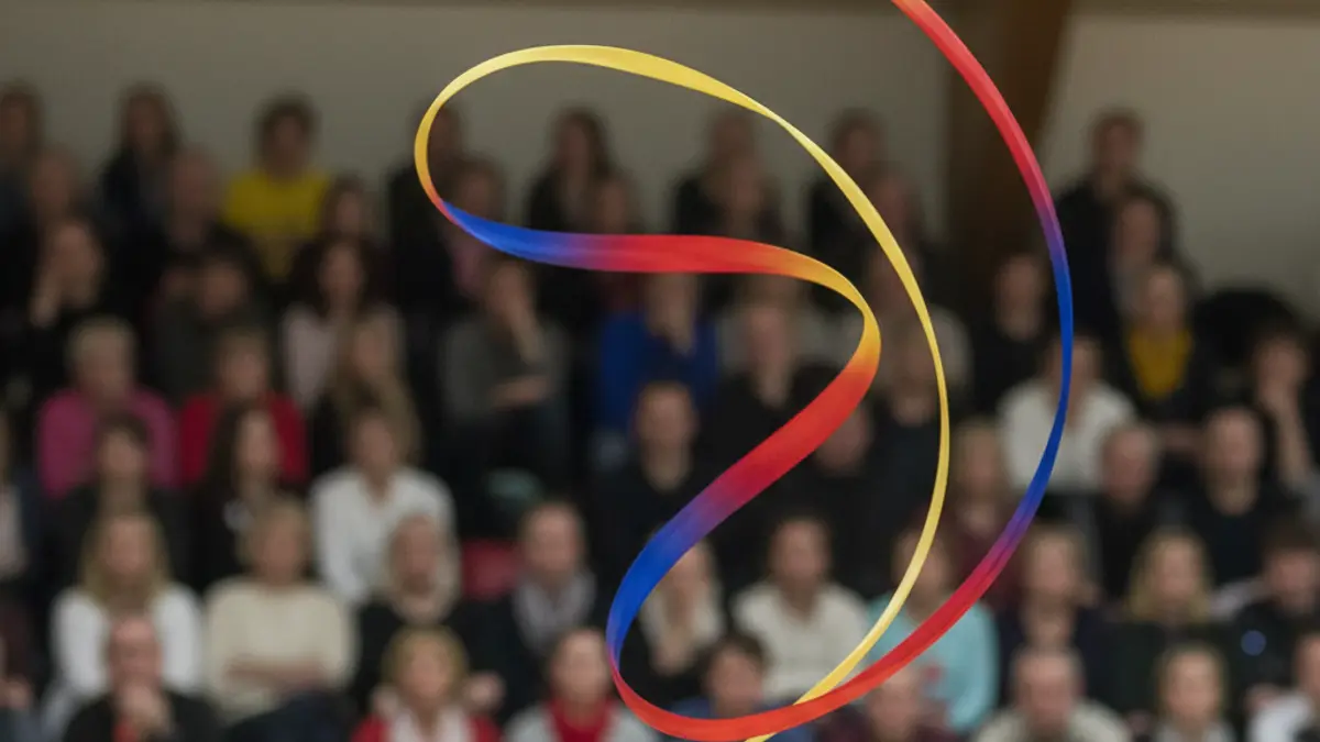 Imatge genèrica d'una cinta de gimnàstica rítmica en moviment, amb un gimnàs desenfocat al fons.