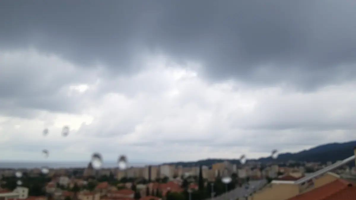 Imagen genérica de un cielo nublado con gotas de lluvia en un cristal, sugiriendo un tiempo inestable.