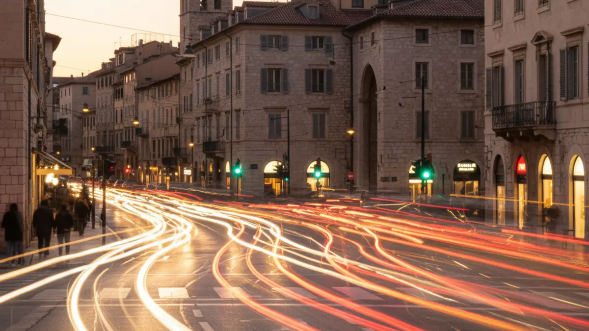 Imagen genérica de tráfico urbano en una ciudad mediterránea al anochecer, con luces de vehículos borrosas.