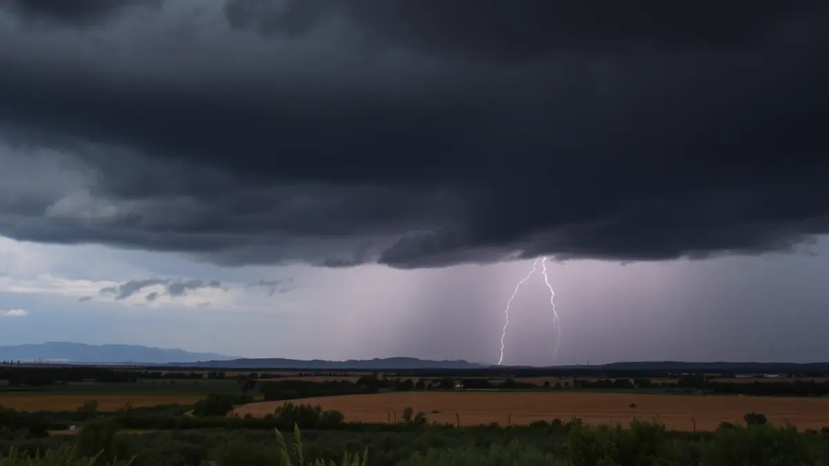 Generic image of storm clouds over a Valencian rural landscape, with distant lightning and heavy rain.