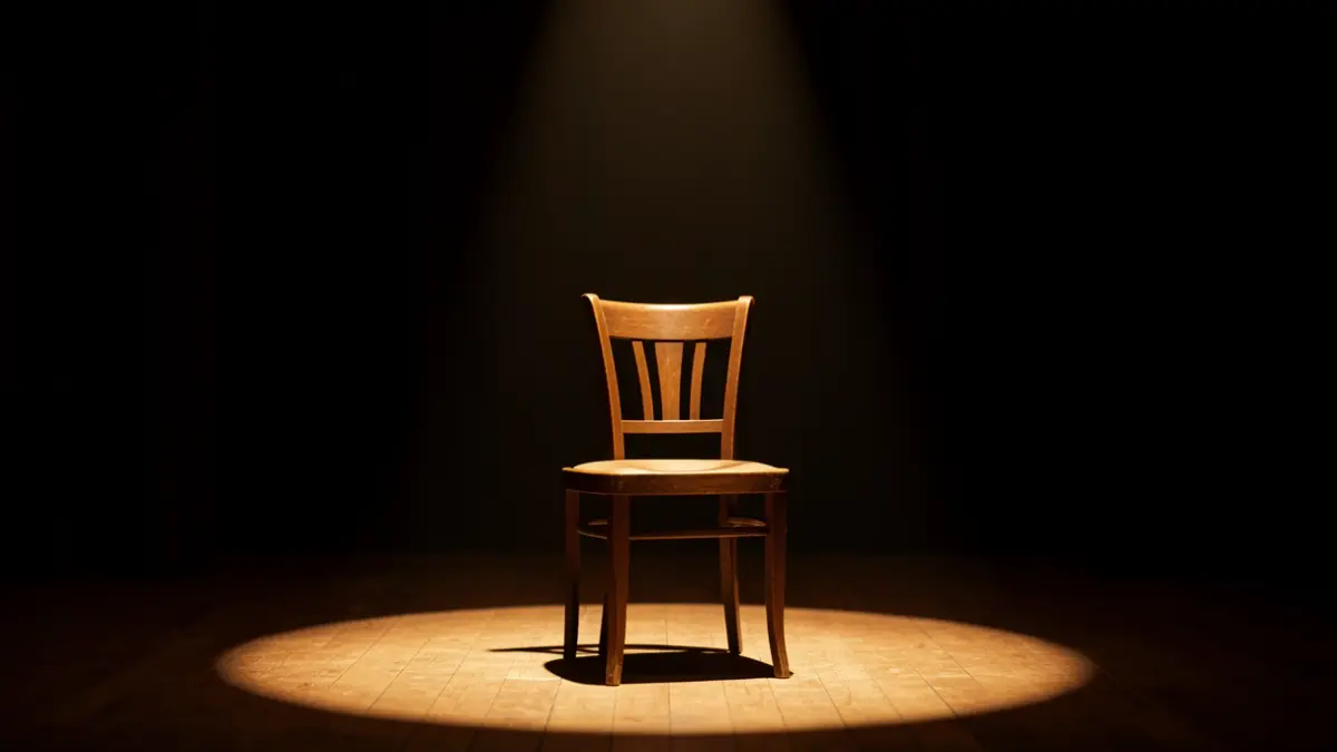 Imagen genérica de un escenario de teatro con una silla iluminada por un foco.