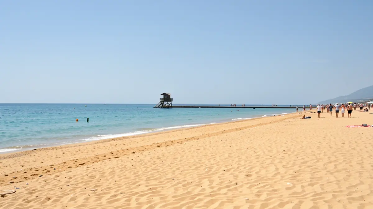 Imatge genèrica d'una platja mediterrània amb sorra daurada i aigua tranquil·la durant l'estiu.