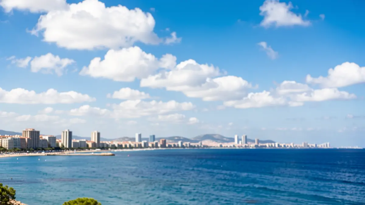 Imagen genérica del cielo y la costa de Benidorm con sol y nubes dispersas.