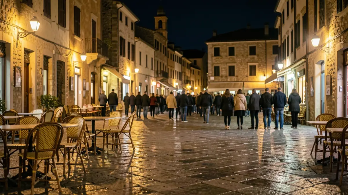Imatge genèrica d'una plaça de poble mediterrani de nit amb mobiliari urbà mullat.