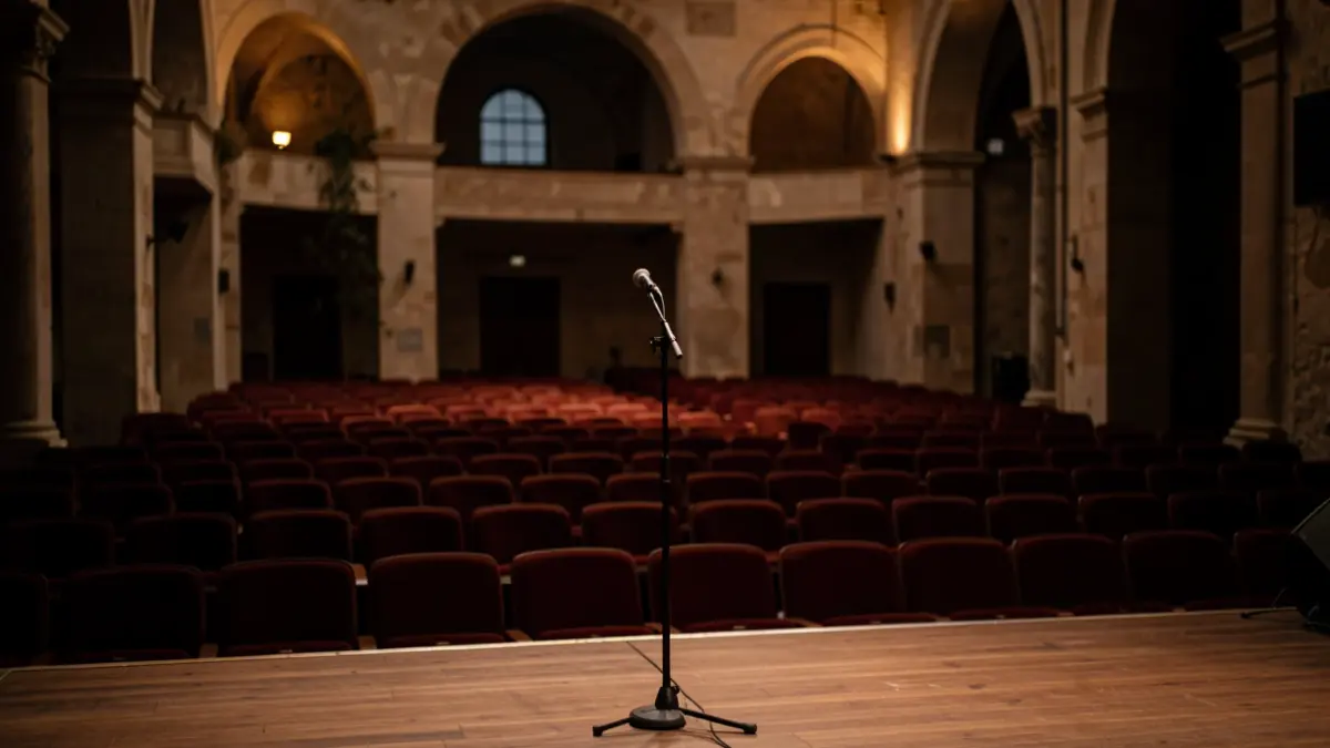 Imagen genérica de una sala de conciertos vacía con un micrófono en el escenario.