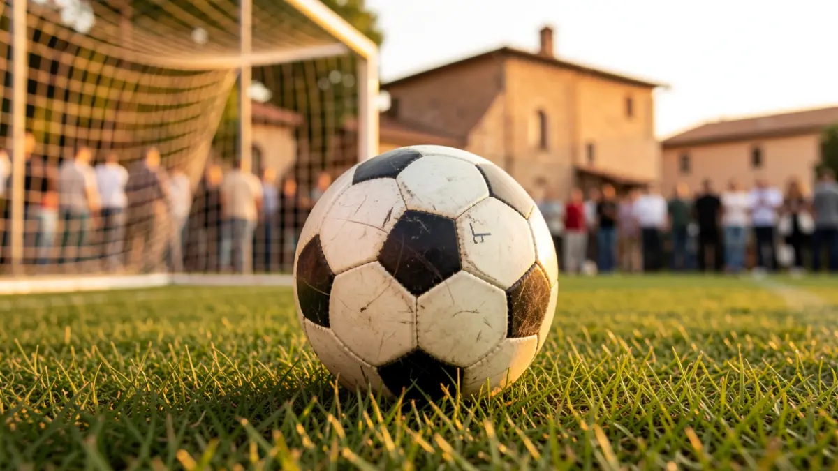Imatge genèrica d'una pilota de futbol sobre gespa, amb la xarxa de la porteria desfocada al fons, sota una llum daurada.